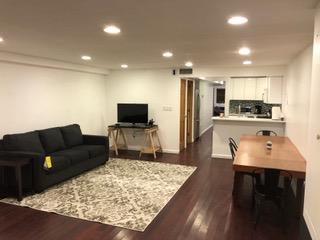 a living room with stainless steel appliances furniture and a view of kitchen