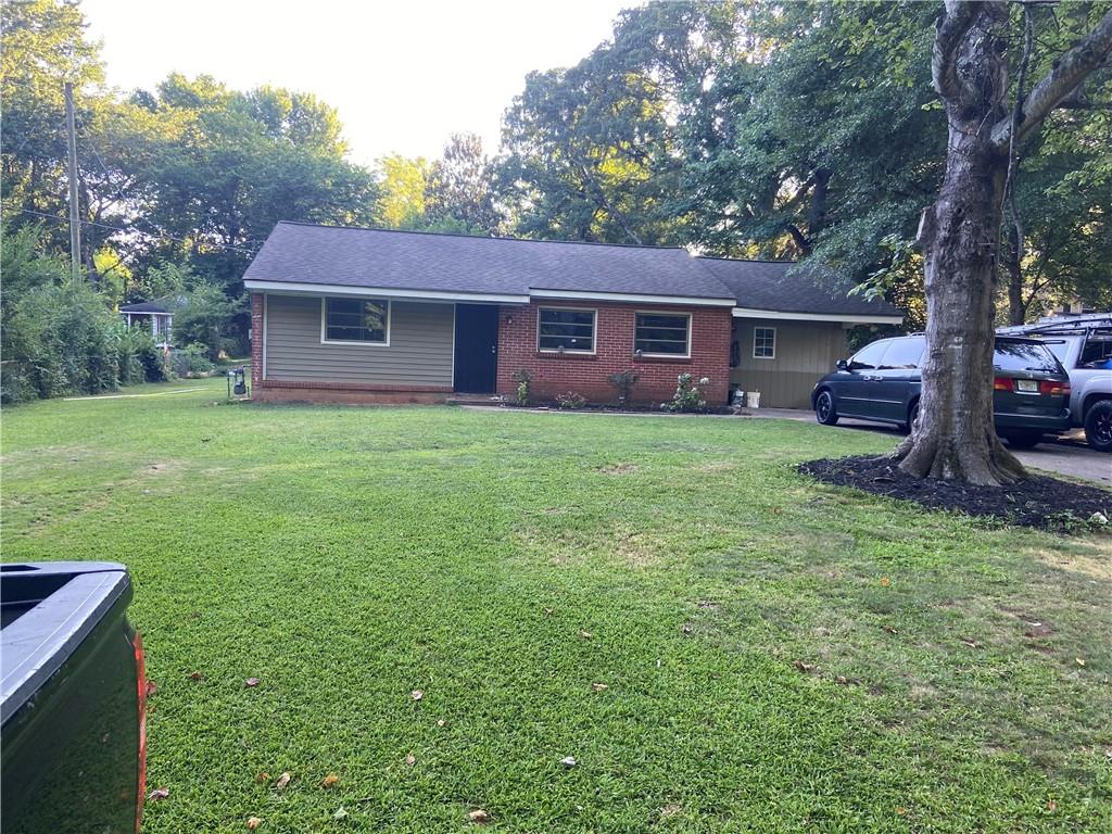 a view of a yard in front of a house with large trees