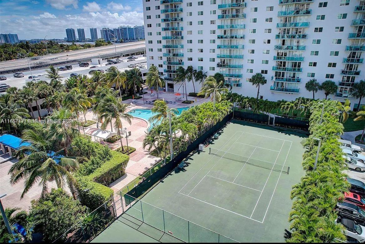 a view of a yard with plants and a tall building