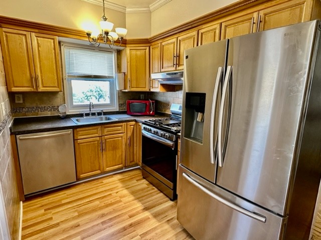 a kitchen with stainless steel appliances a refrigerator a sink a stove and cabinets