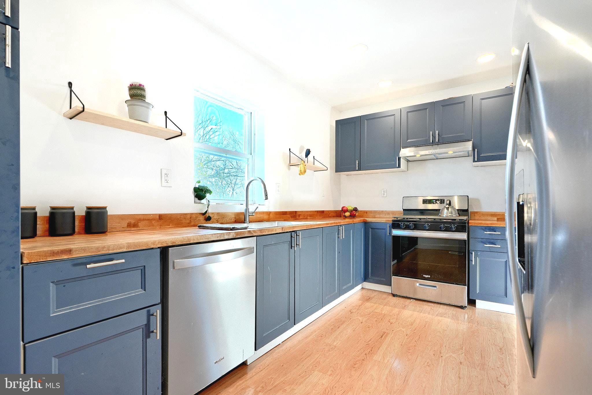 a kitchen with stainless steel appliances a sink stove and refrigerator