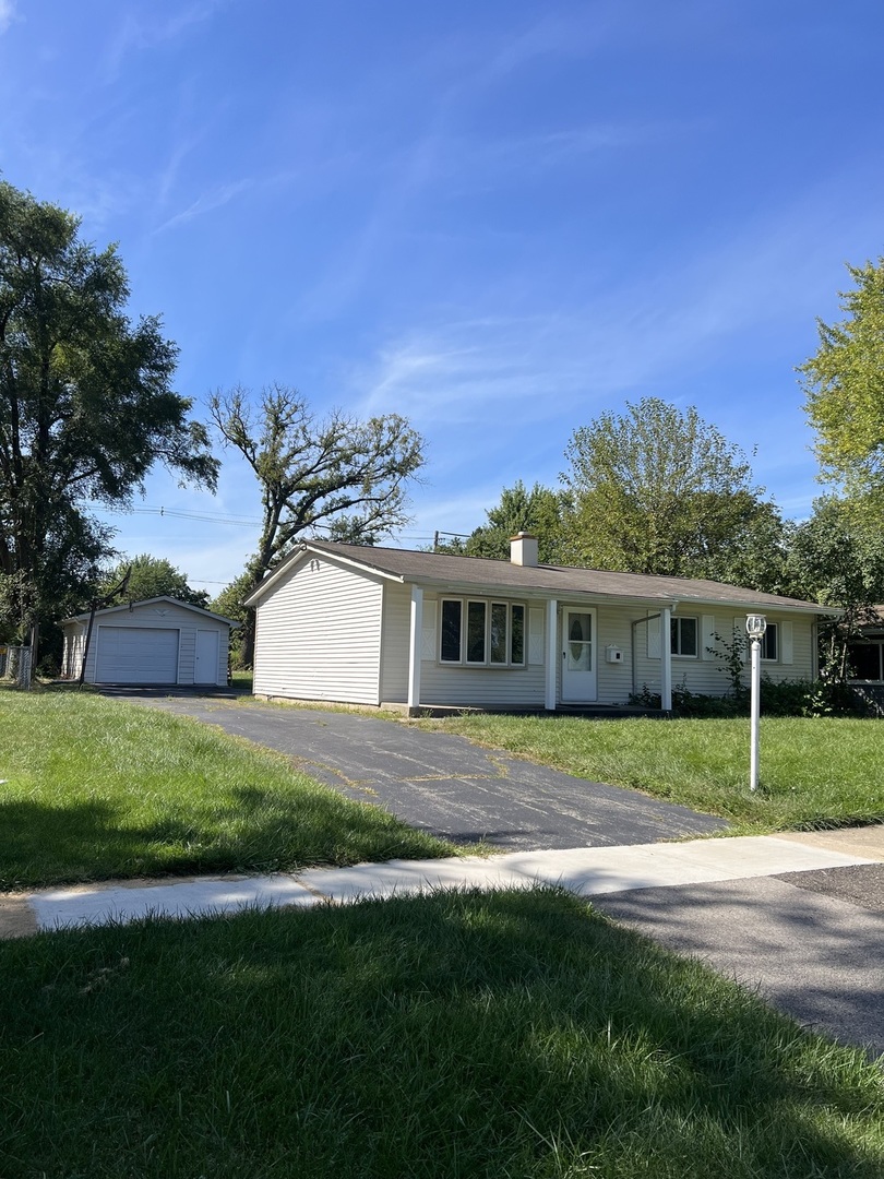 a front view of a house with a yard and trees