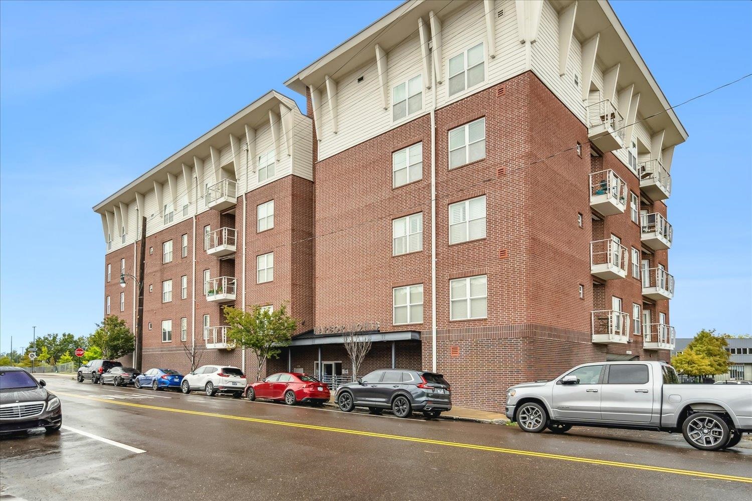 a view of a building and car parked on the road