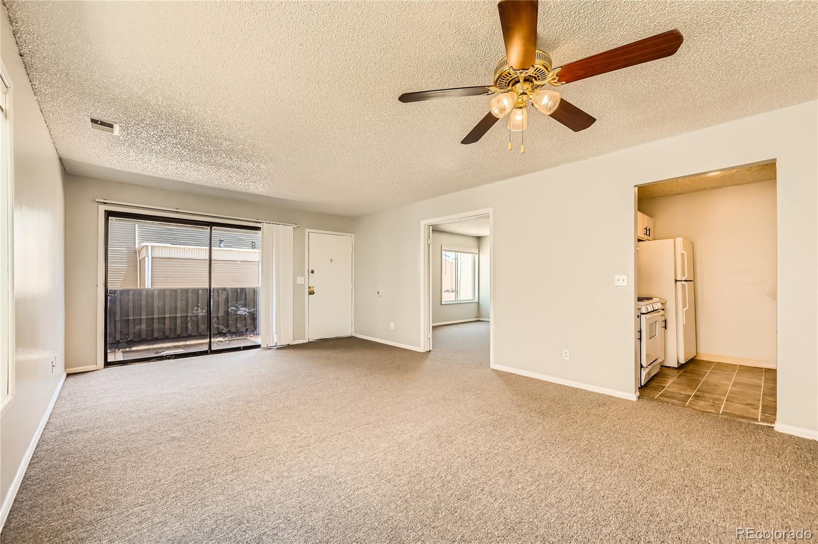 a view of a livingroom with a ceiling fan and window