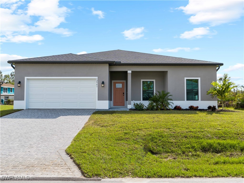 a front view of house with yard and garage