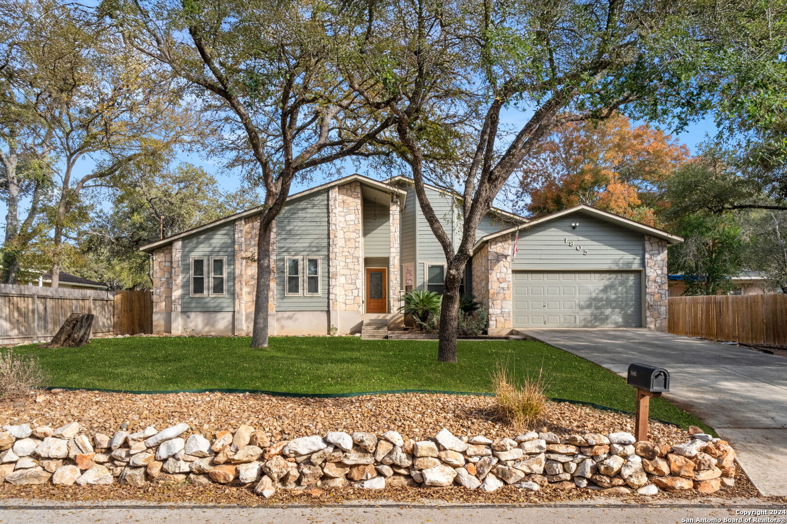 a front view of a house with a yard and trees