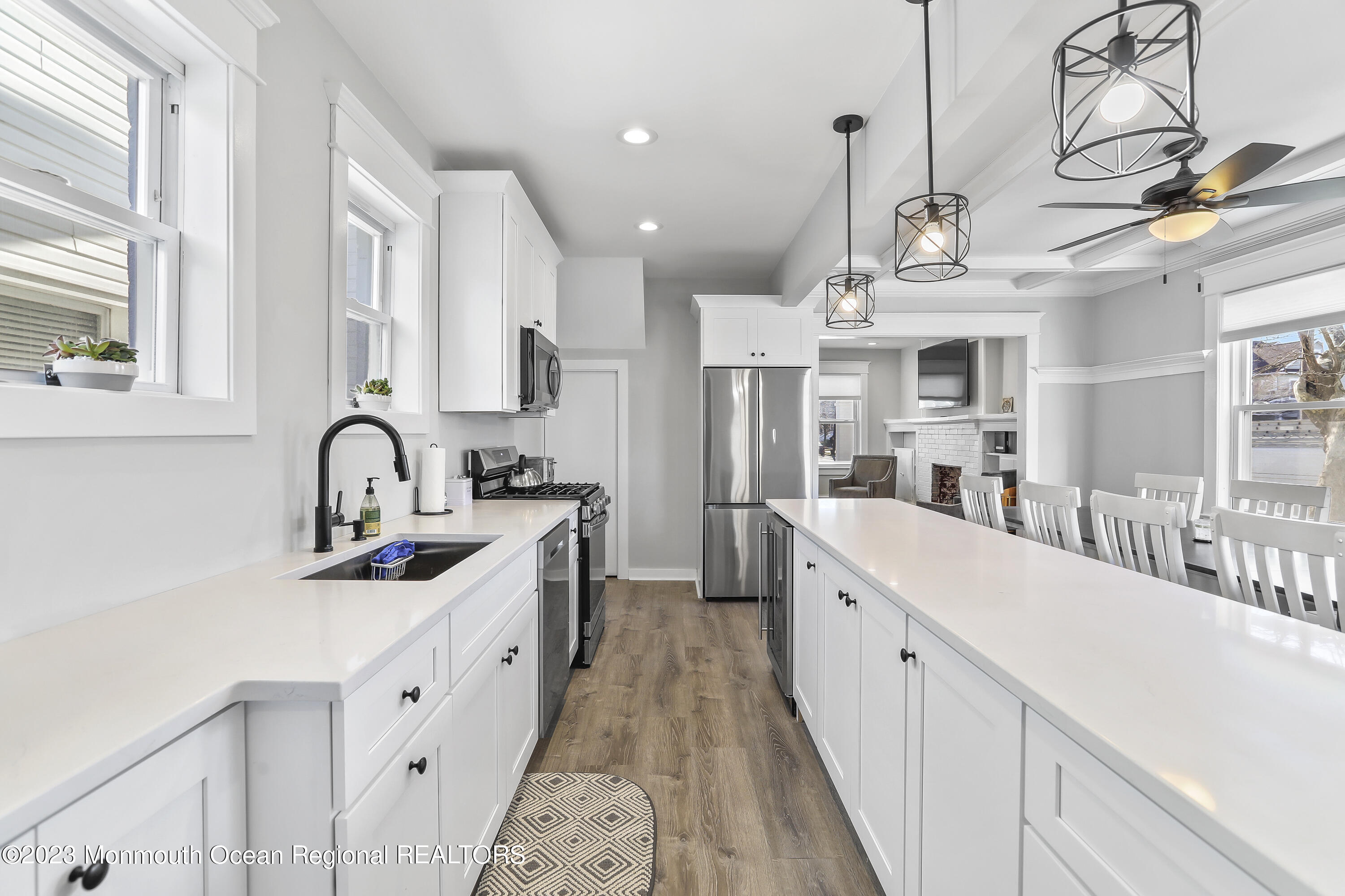 a large white kitchen with stainless steel appliances sink and cabinets
