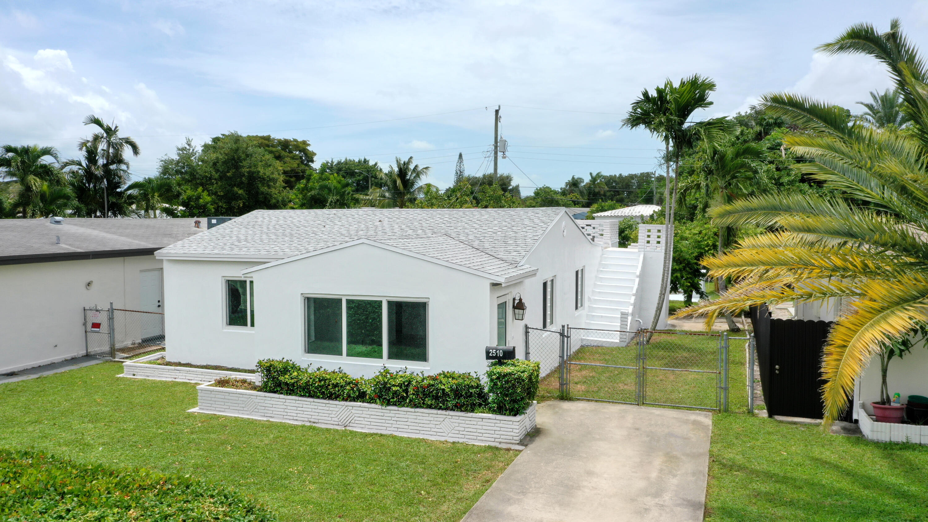 a front view of a house with a yard and potted plants