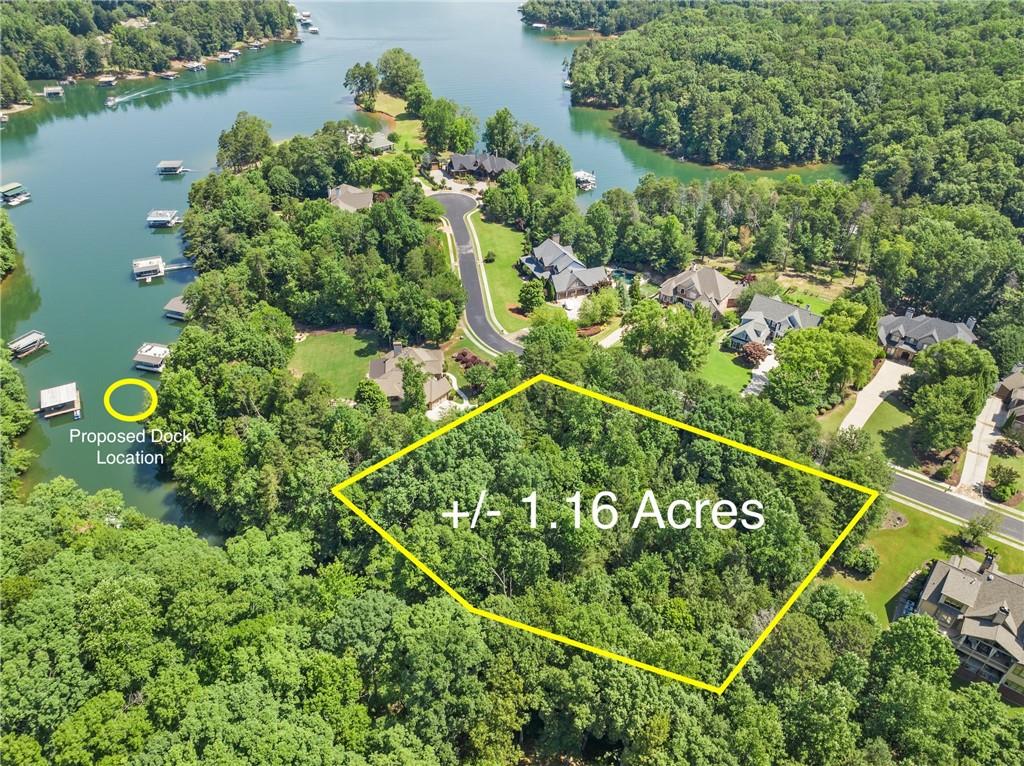 an aerial view of a residential houses with outdoor space and lake view