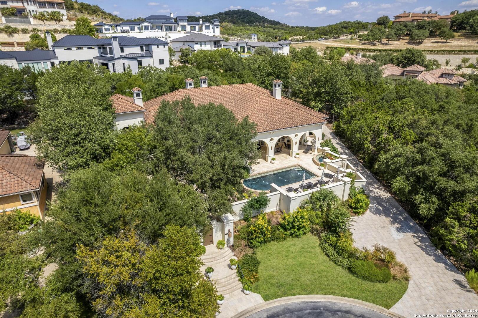 an aerial view of a house with a garden and lake view