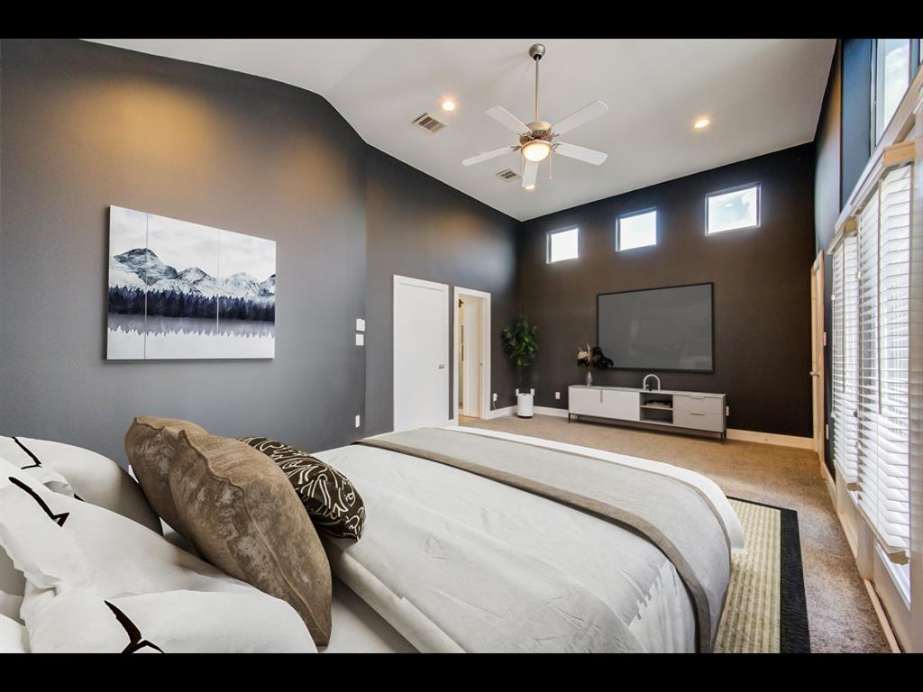 a bedroom with a large bed and a chandelier