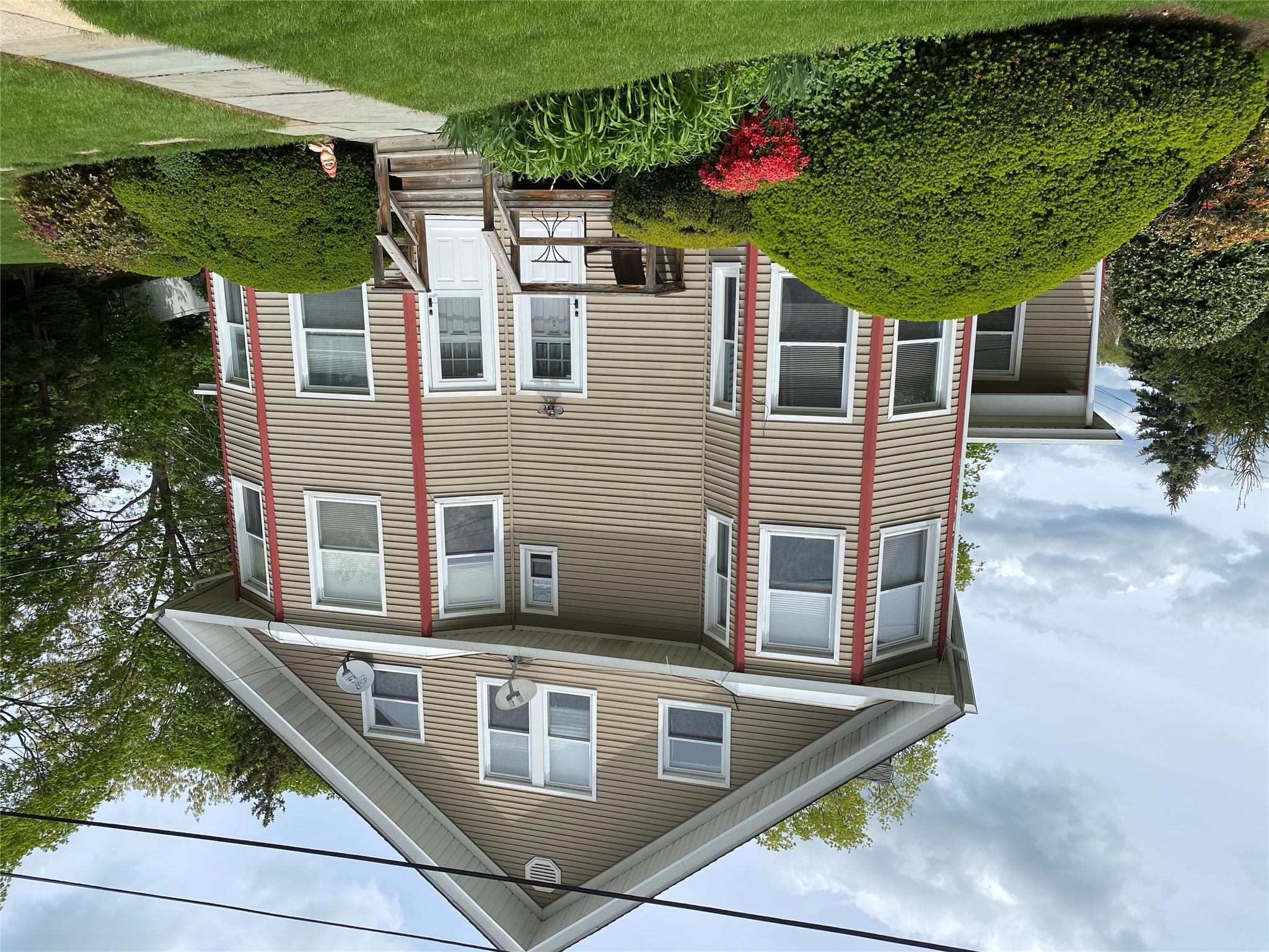 a front view of a house with a yard and potted plants