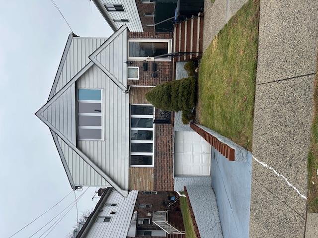 View of front of property with a garage and a front lawn