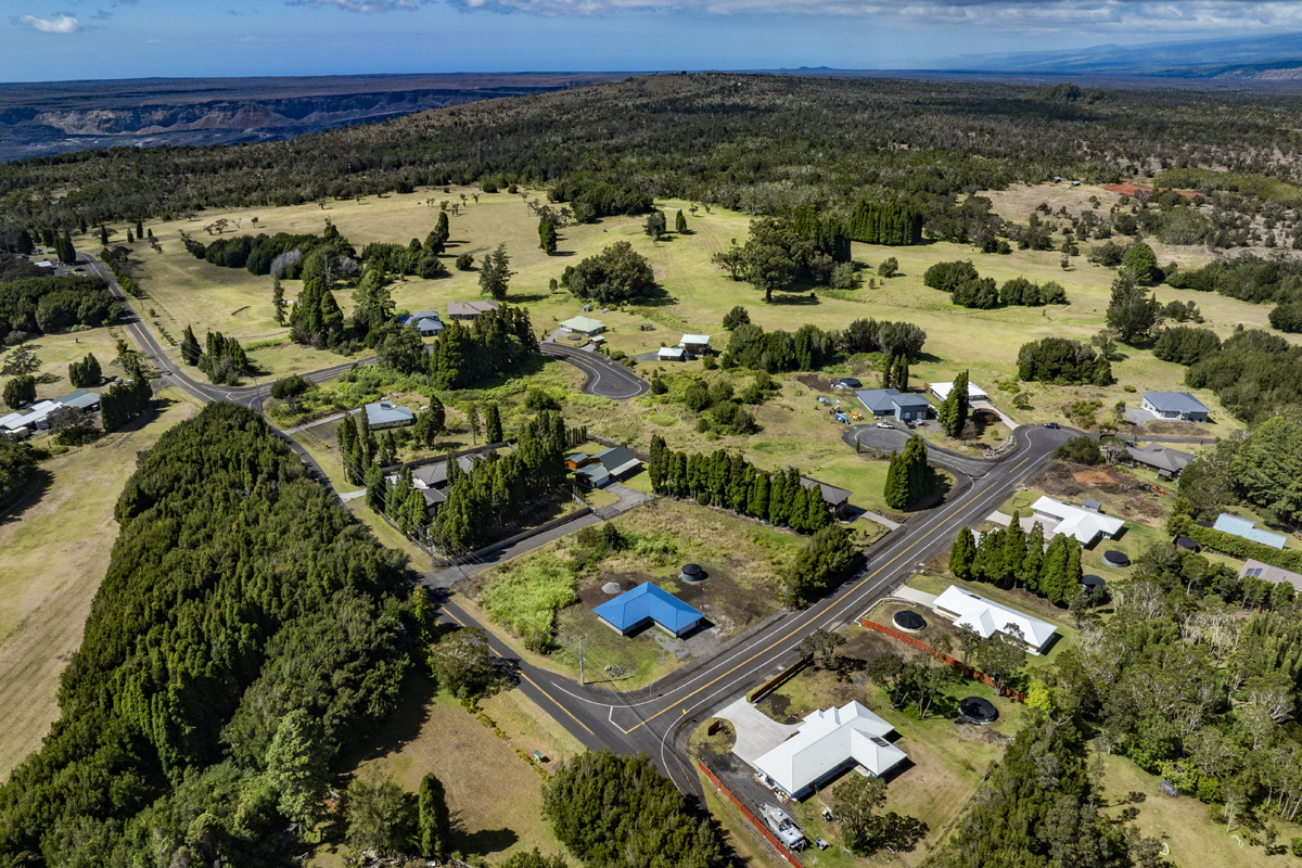 an aerial view of a residential houses with a yard