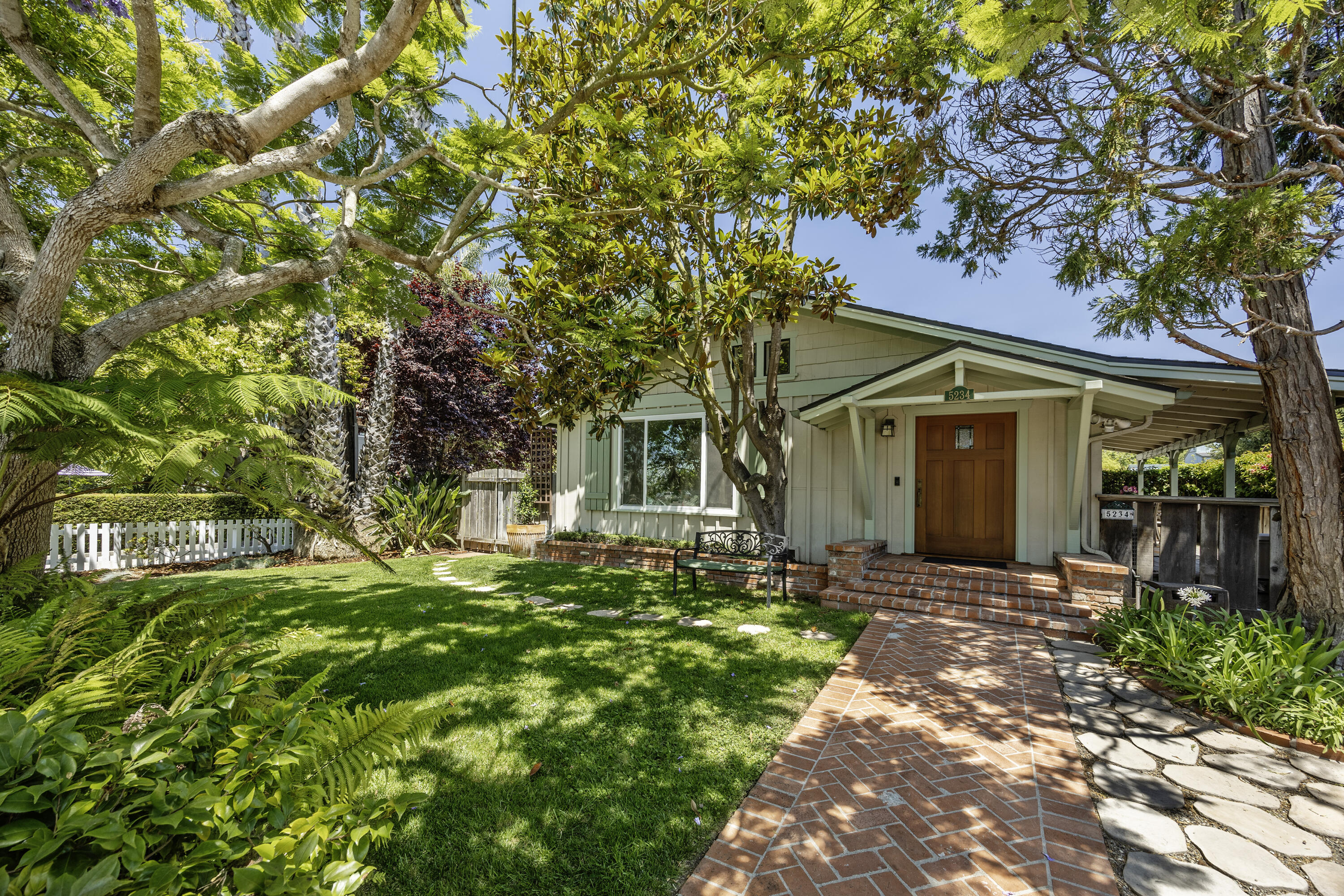 a front view of a house with a garden