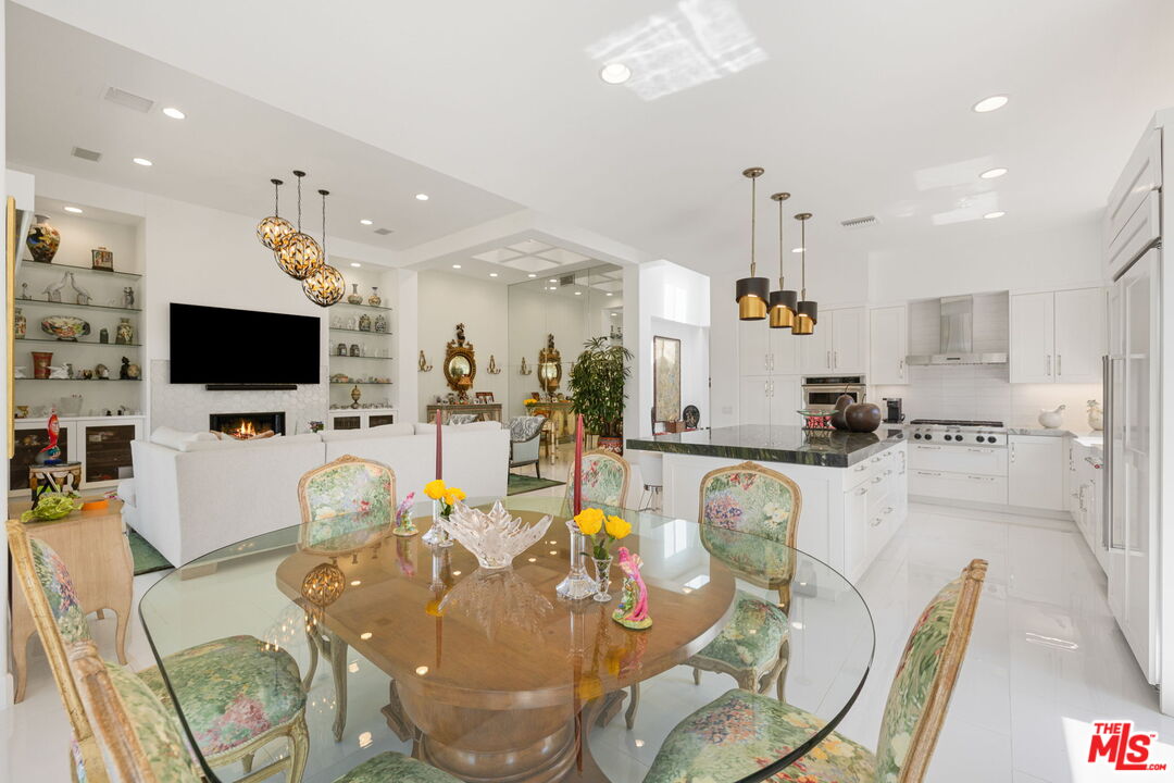 a living room with furniture a flat screen tv and kitchen view