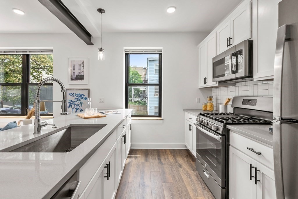 a kitchen with stainless steel appliances granite countertop a sink stove and refrigerator