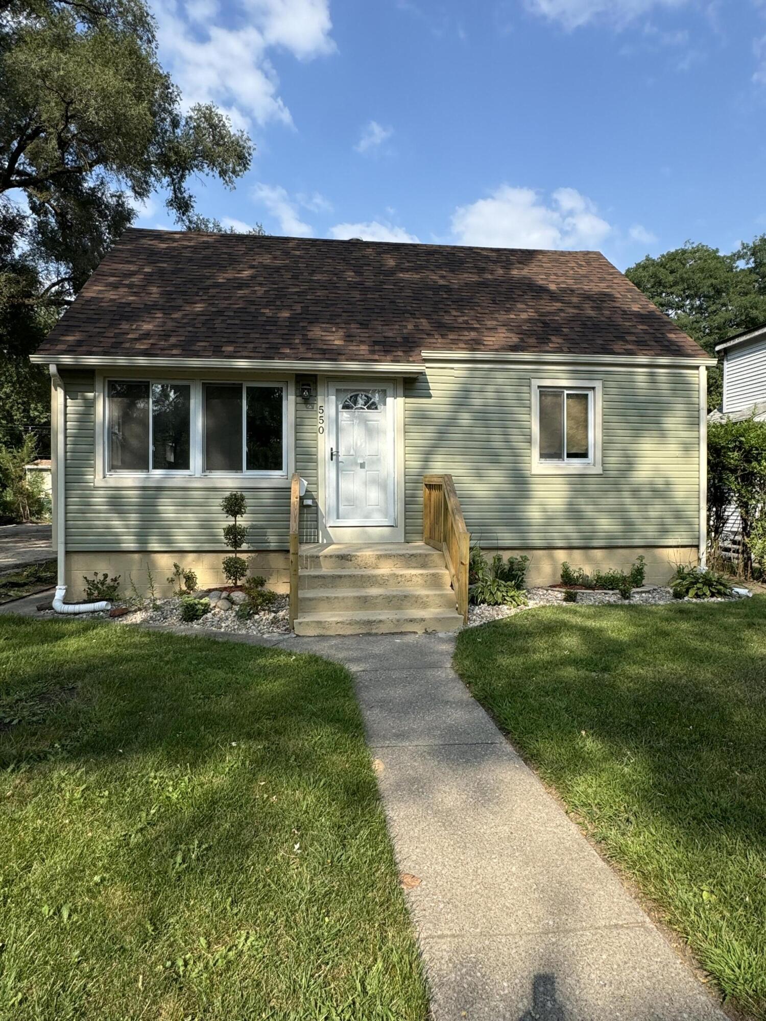 a front view of house with yard and green space