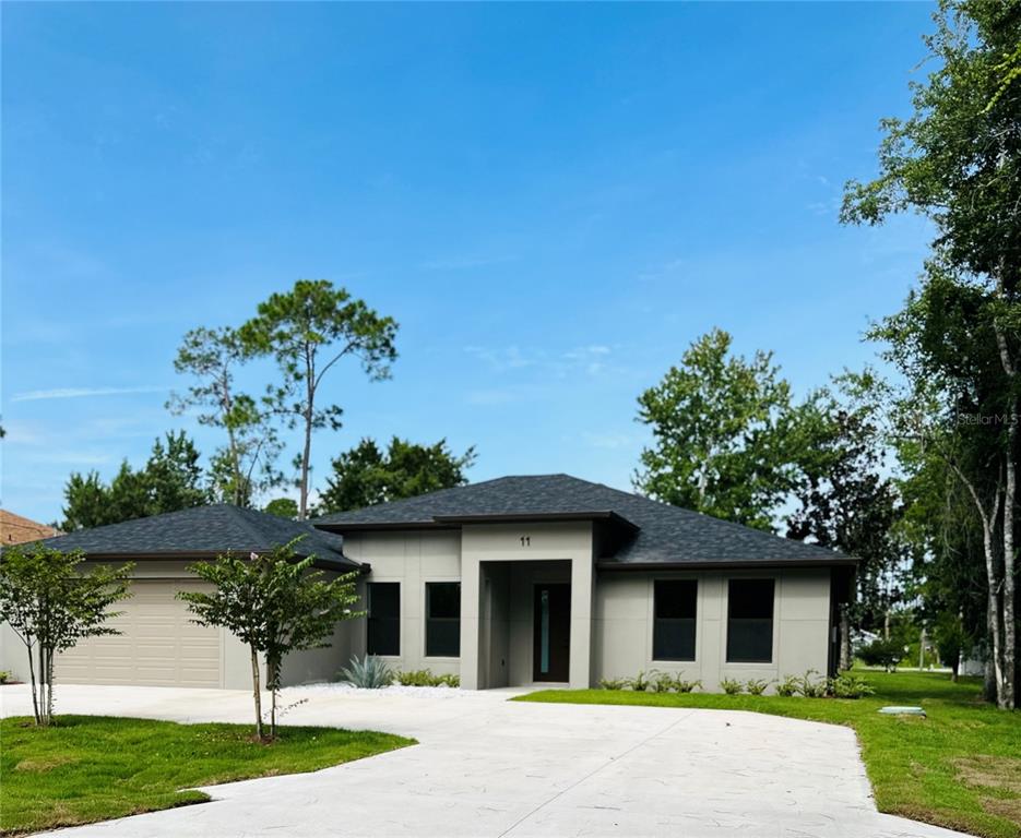 a front view of a house with a yard and trees