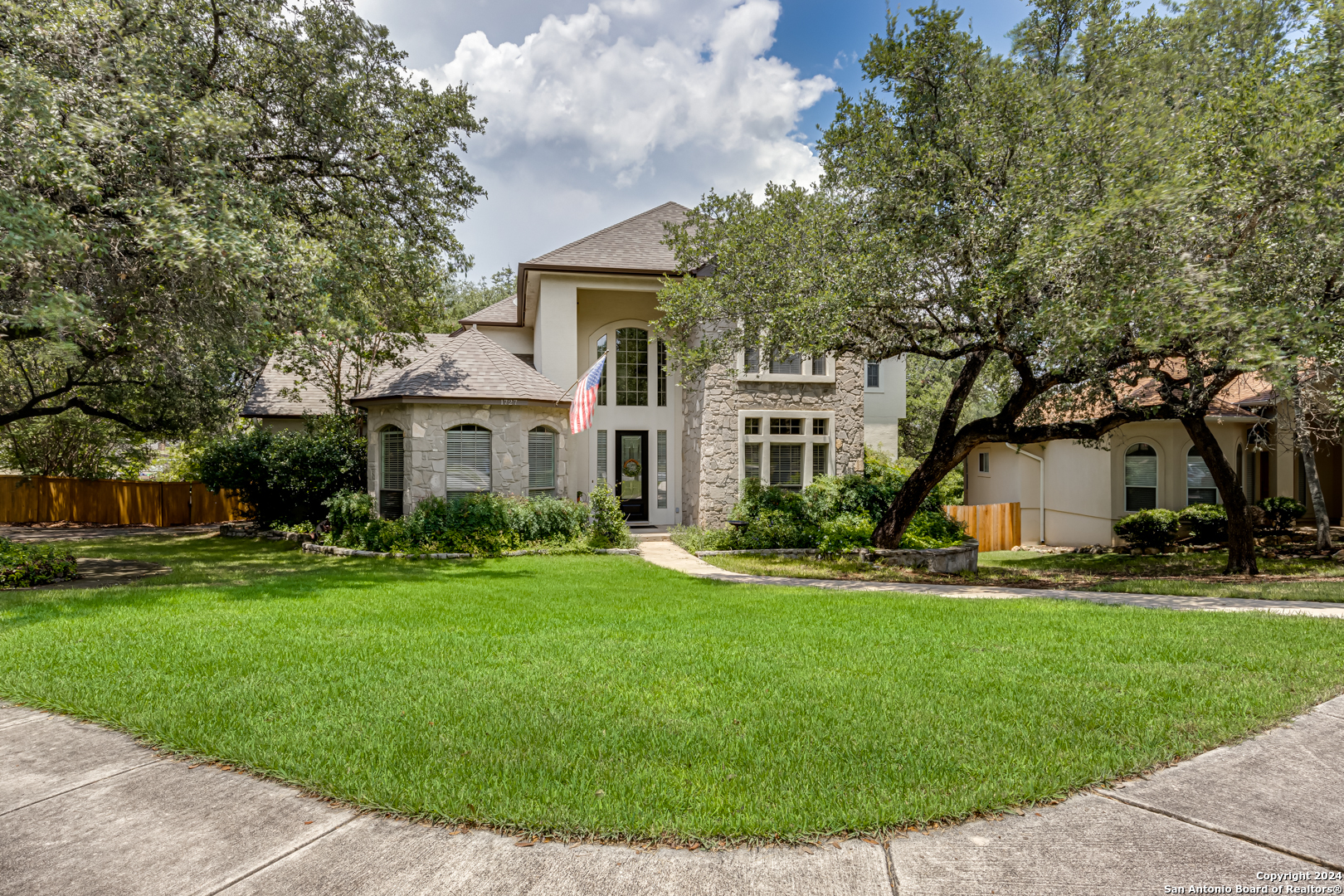 a front view of a house with a yard and trees