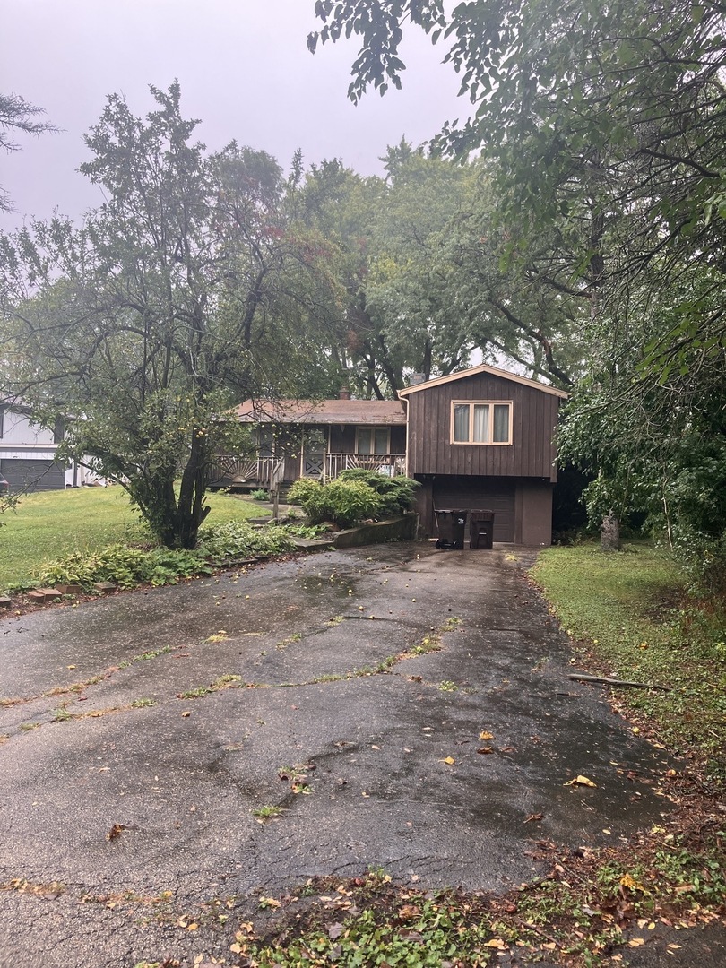 a view of a house with a yard and a large tree