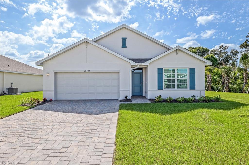 Ranch-style house featuring central air condition unit, a front lawn, and a garage