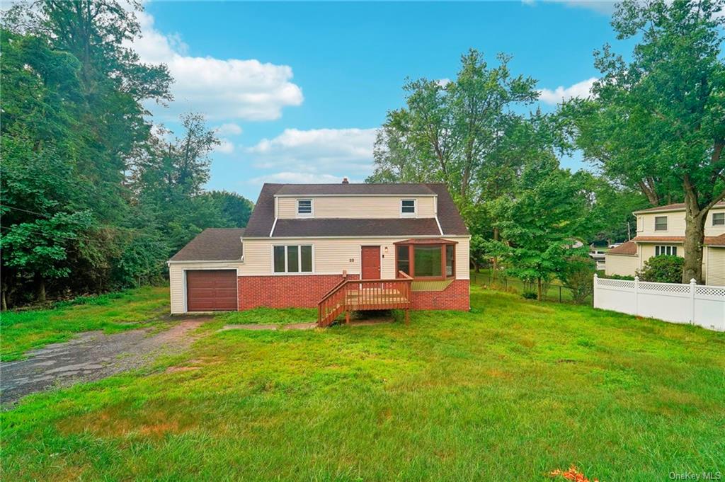 View of front of house with a garage and a front lawn