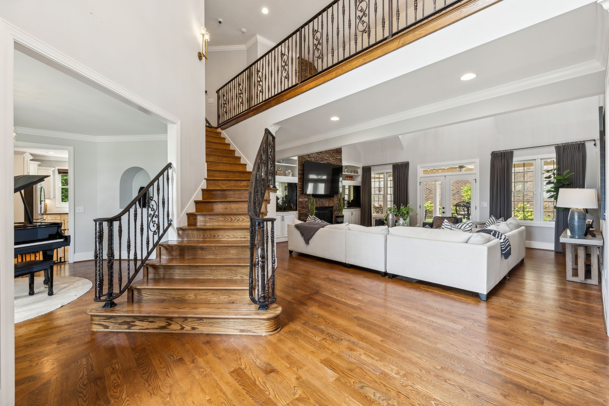 a living room with wooden floor and a chandelier