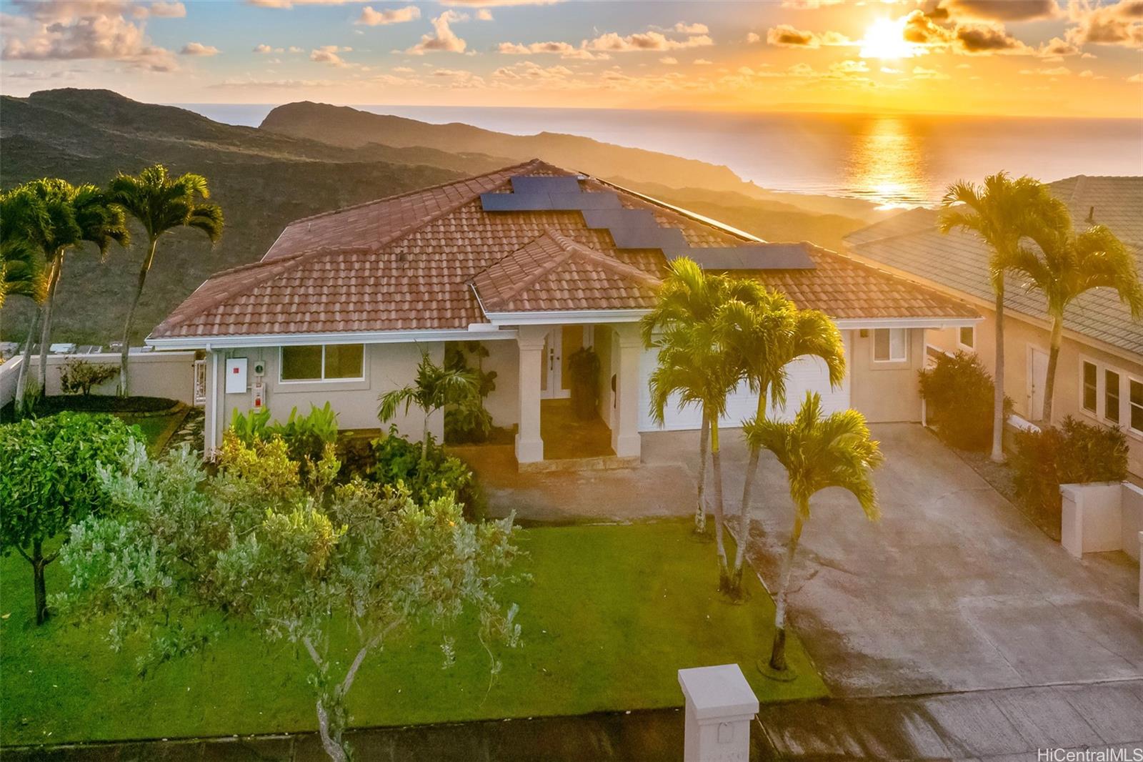 a front view of a house with a yard and mountain view