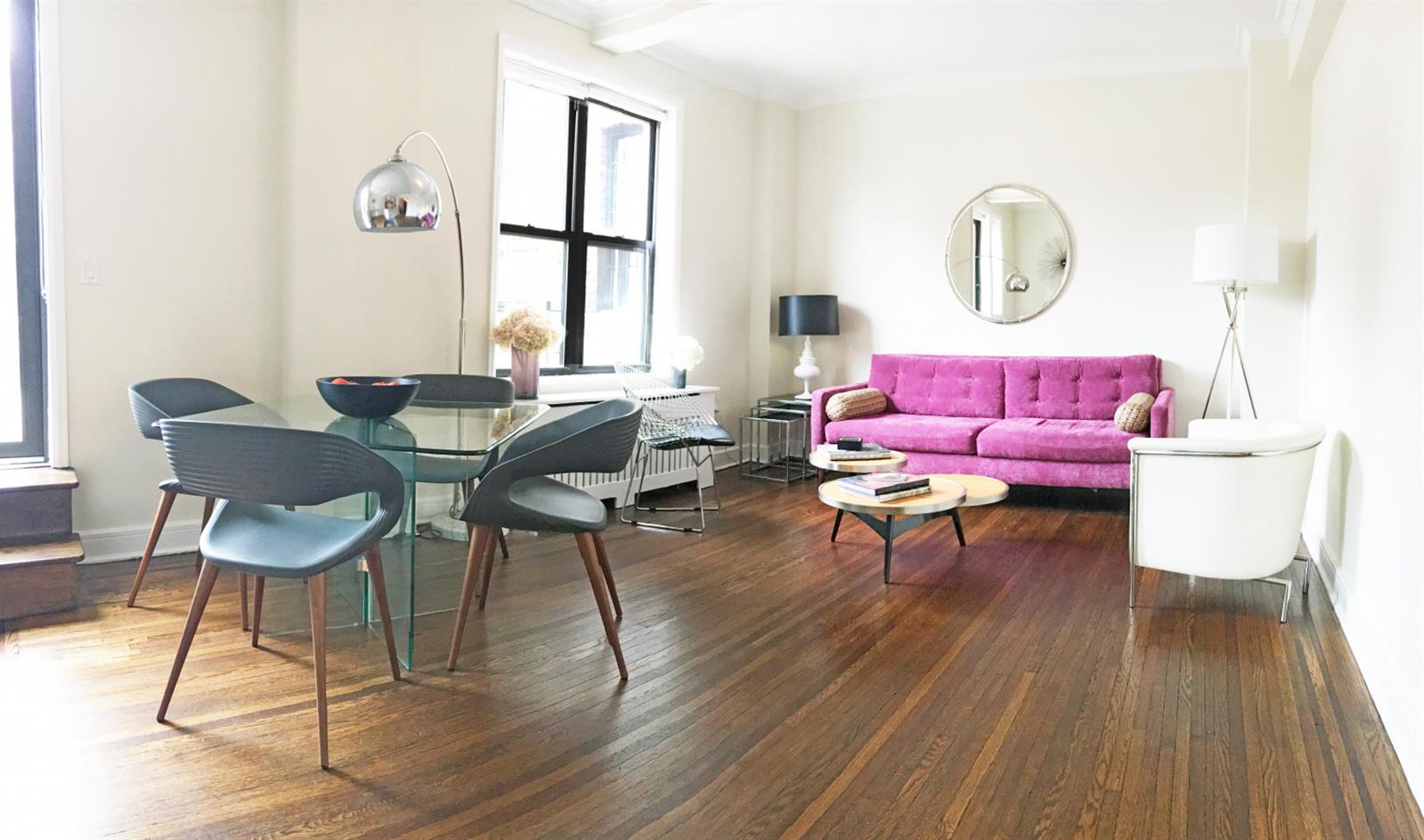 a living room with furniture a wooden floor and a window