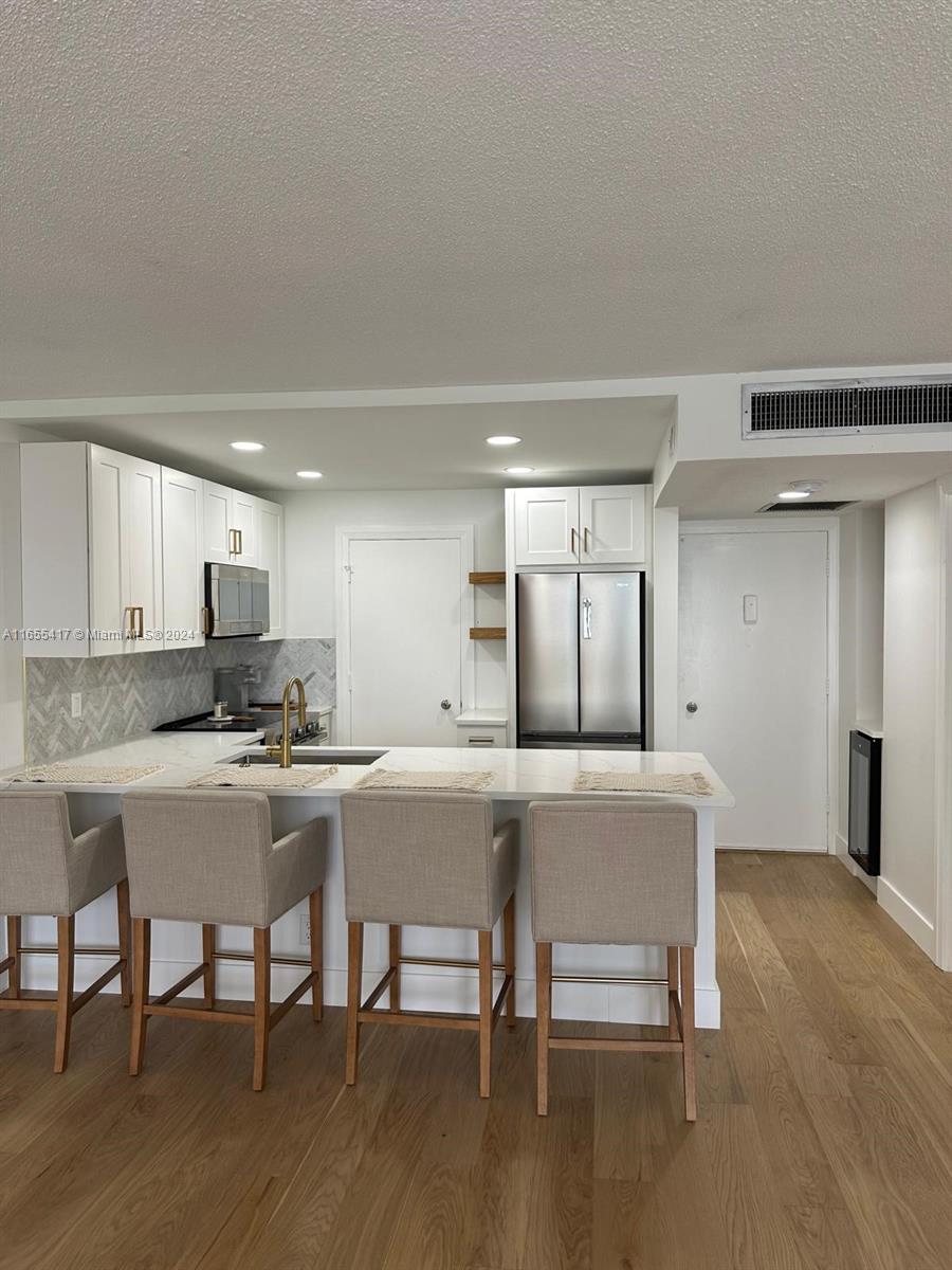 a kitchen with a dining table chairs and wooden floor