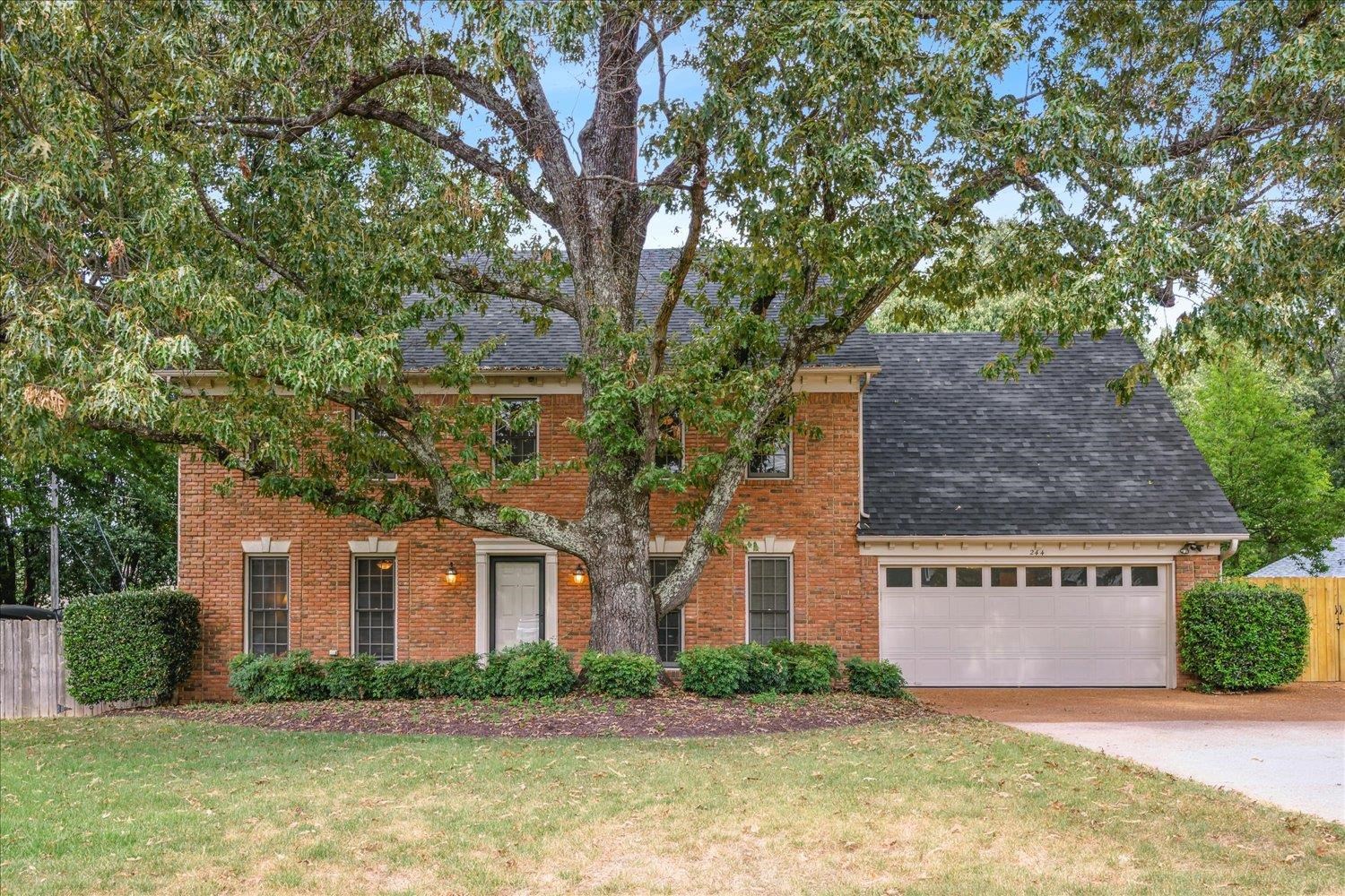 a front view of house with yard and trees around