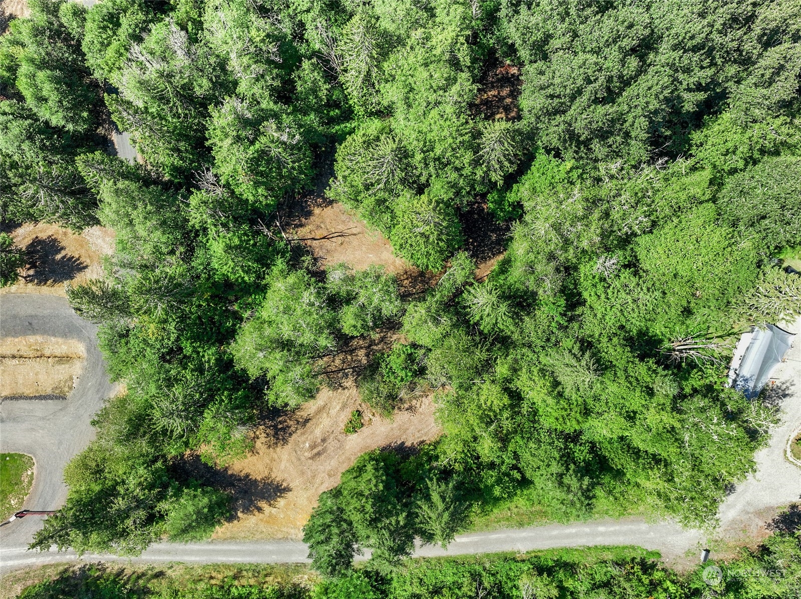 an aerial view of residential house with outdoor space and trees all around