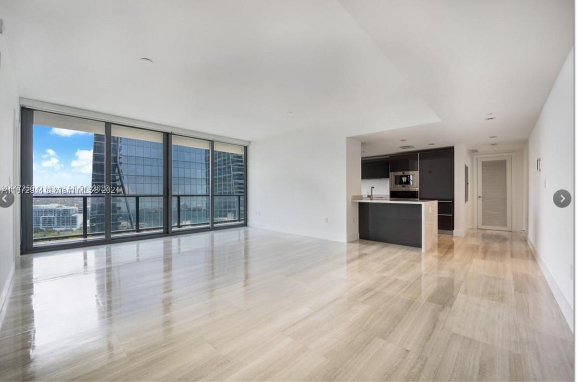 a view of empty room with wooden floor and a fireplace