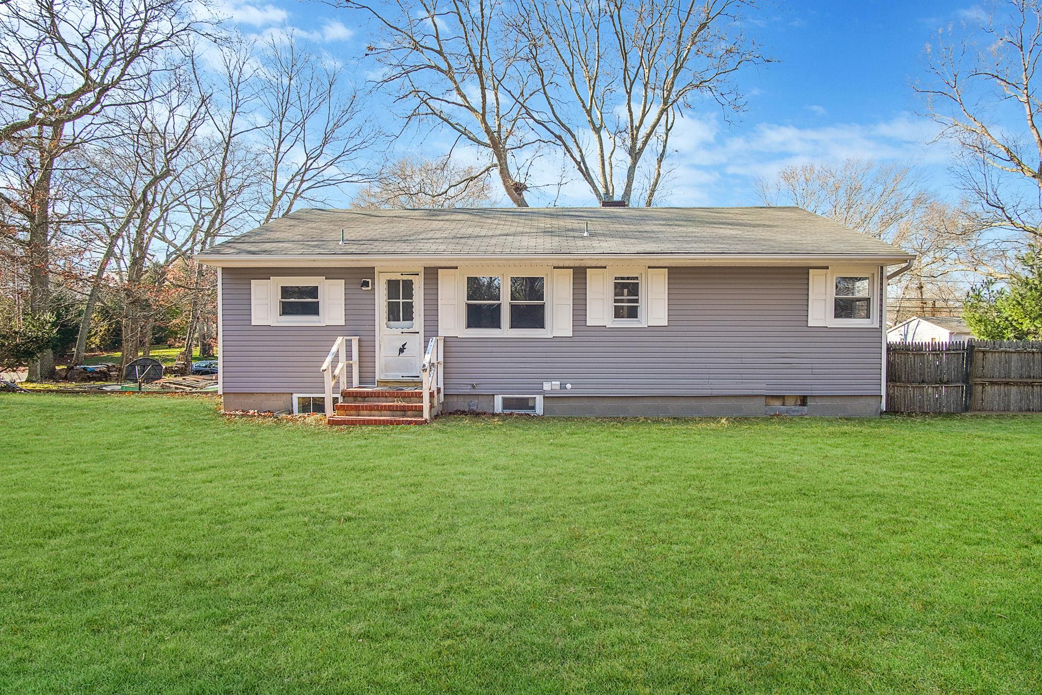 Back of house with a lawn