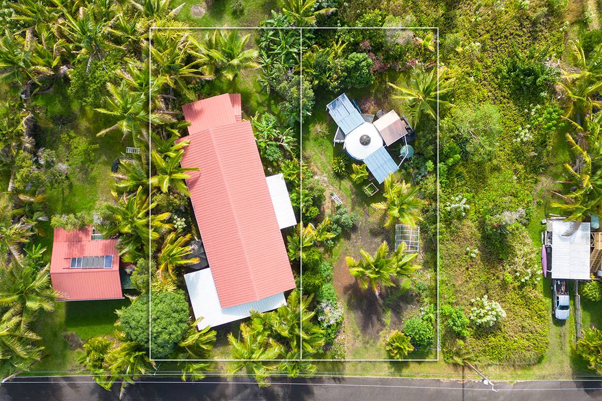 an aerial view of a house with a yard and large trees