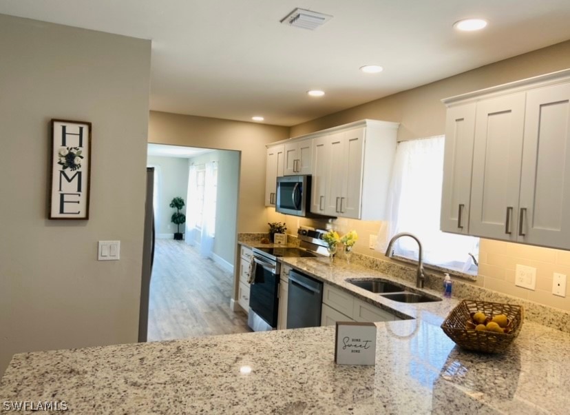 a kitchen with stainless steel appliances granite countertop a sink stove and refrigerator