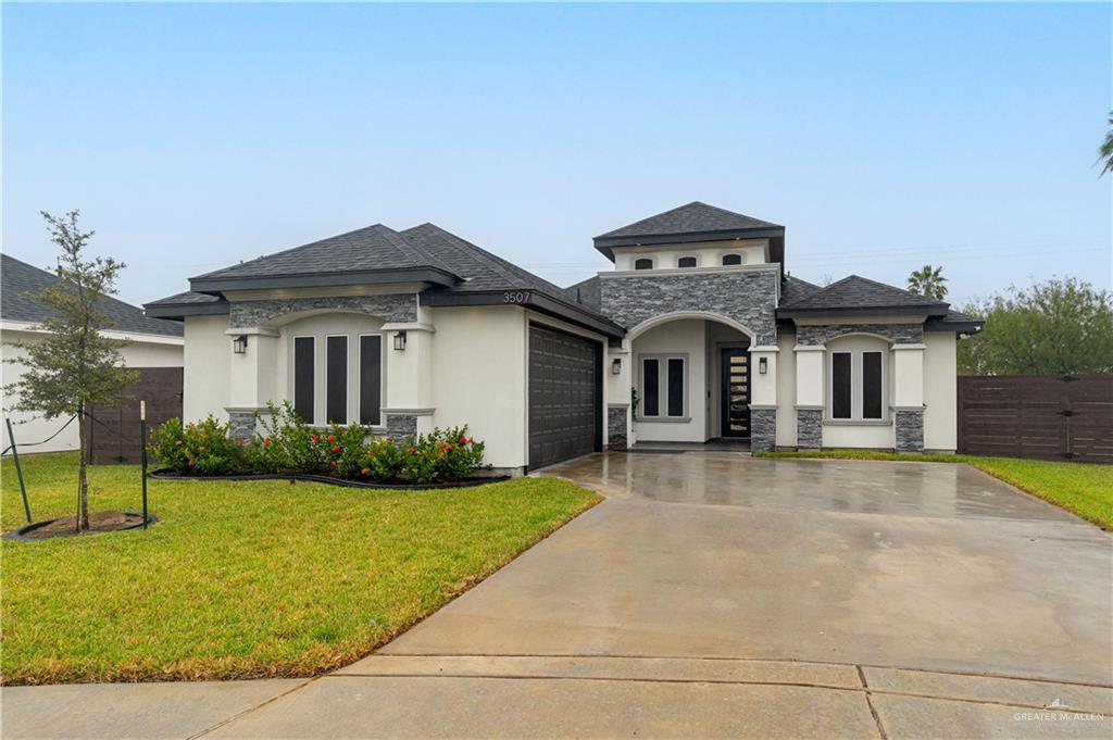 View of front of property with a garage and a front lawn