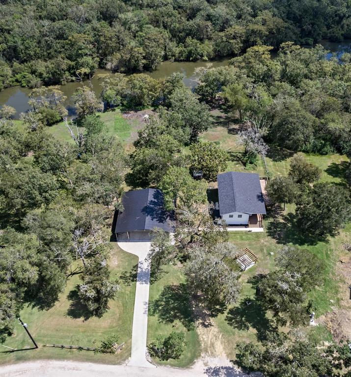 an aerial view of residential house with outdoor space and trees all around