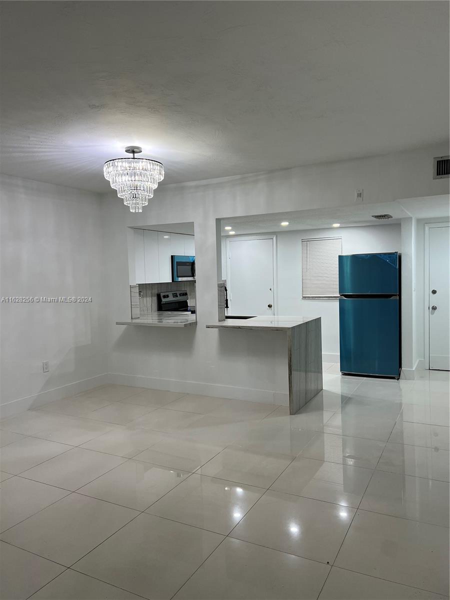 a view of kitchen with kitchen island and stainless steel appliances