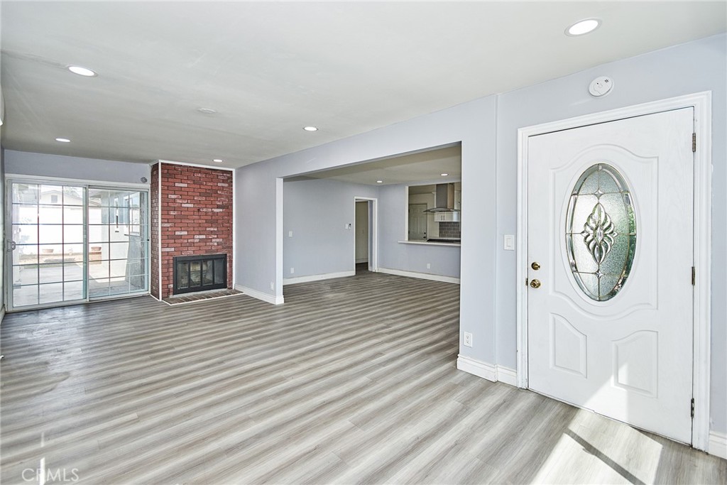 an empty room with wooden floor mirror and windows