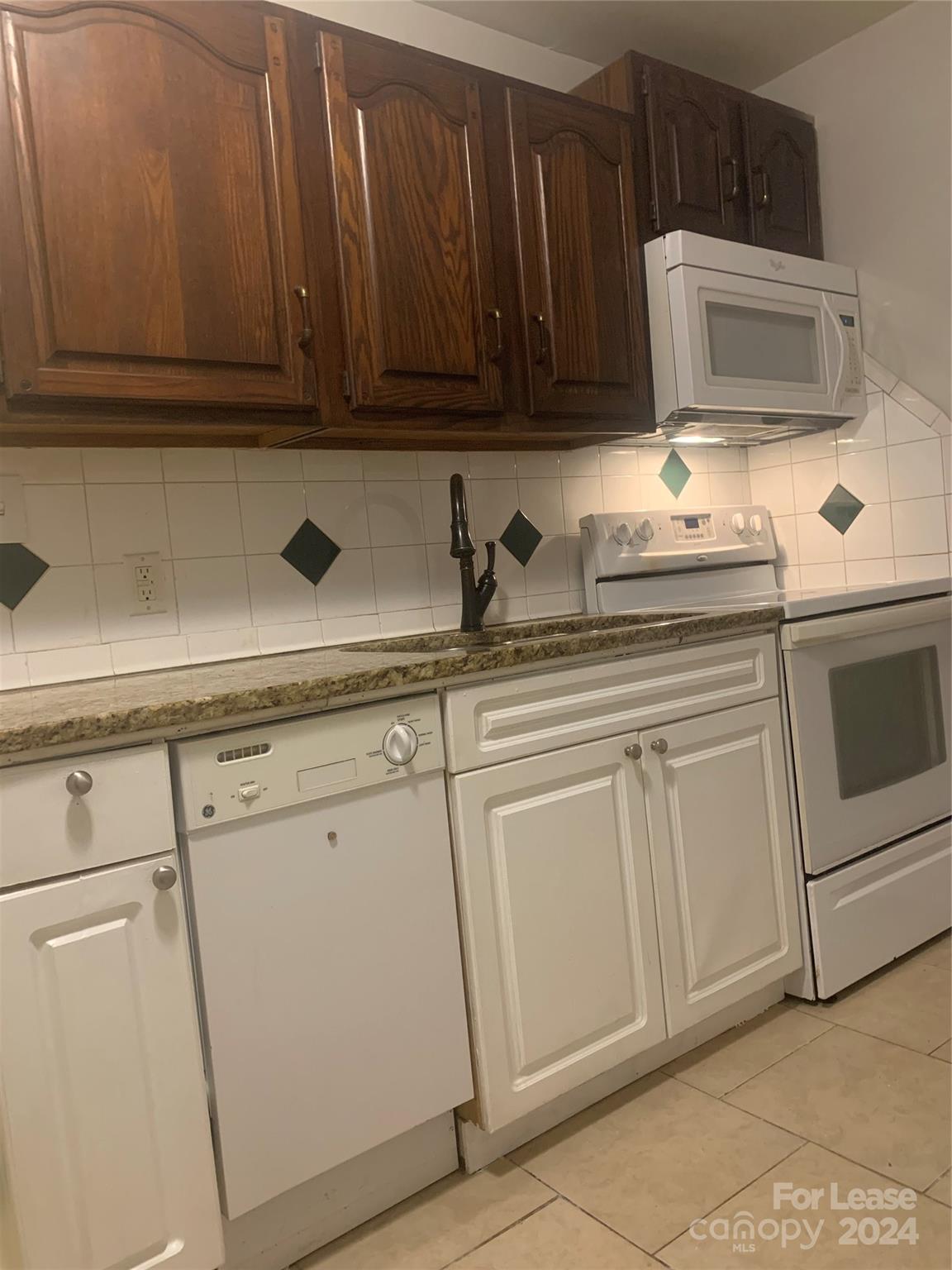 a kitchen with white cabinets and white appliances