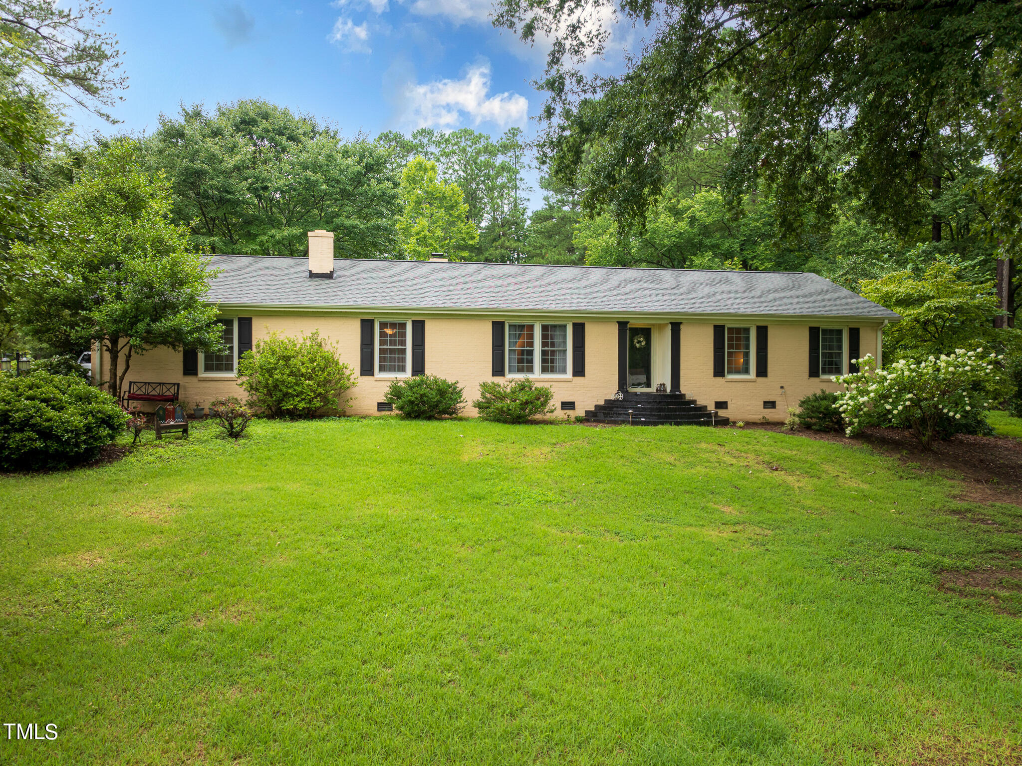 a front view of a house with a yard and green space