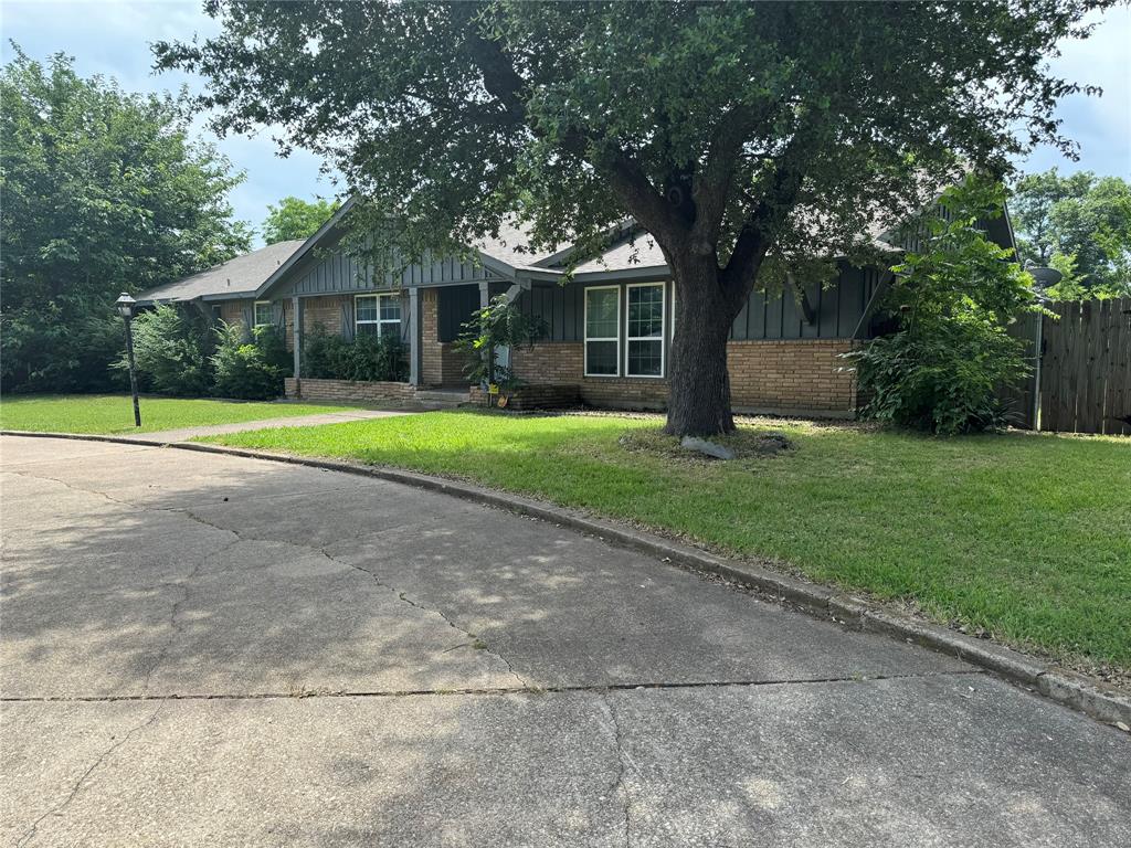 a front view of a house with a yard and trees