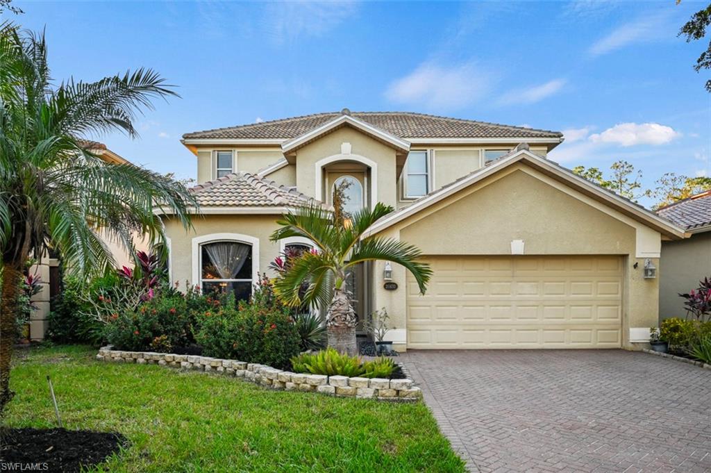 View of front of property featuring a front lawn and a garage