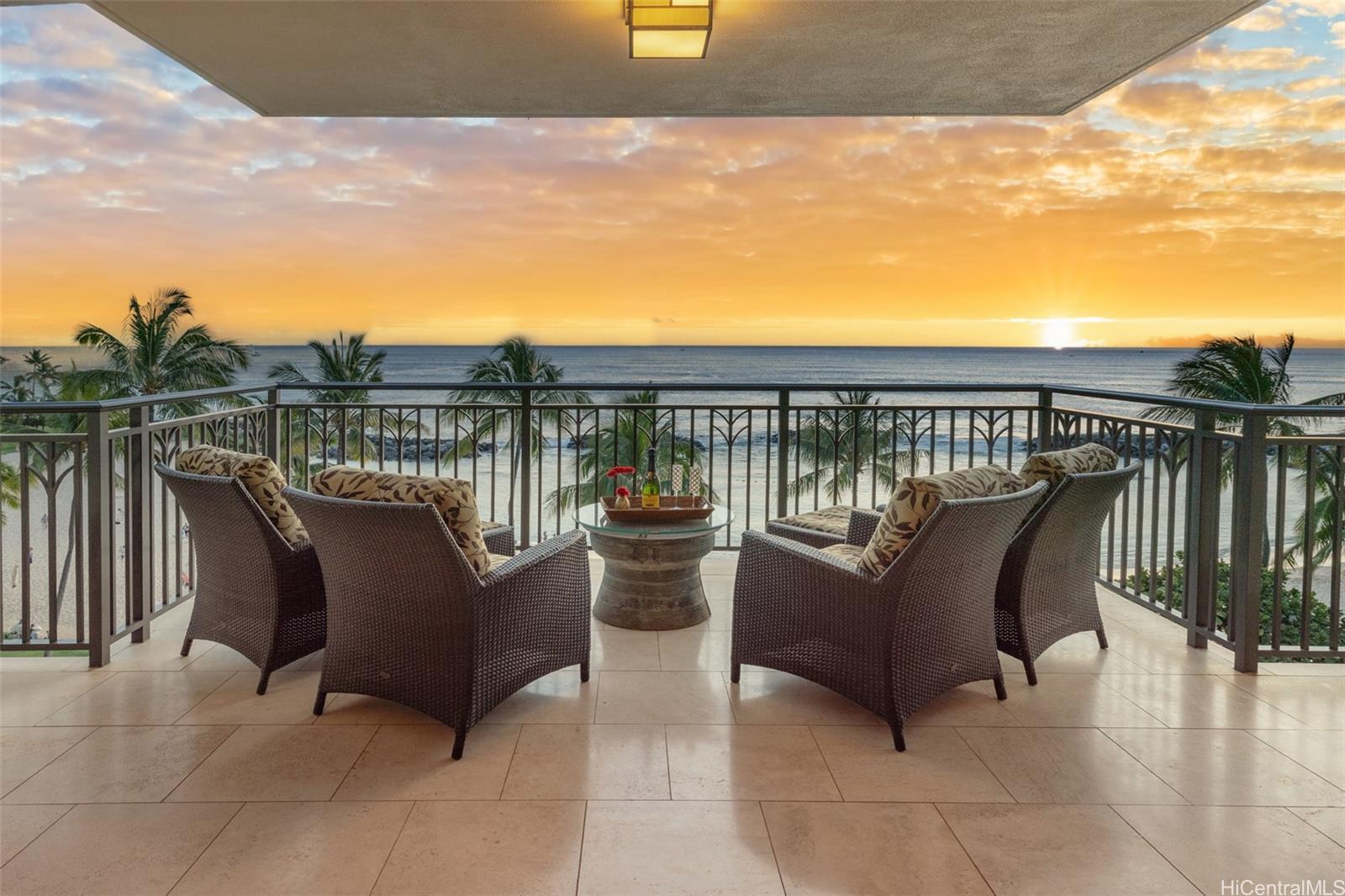 a balcony with couple of couches and potted plants