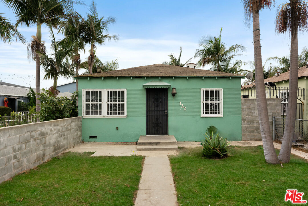 a front view of a house with a garden and yard