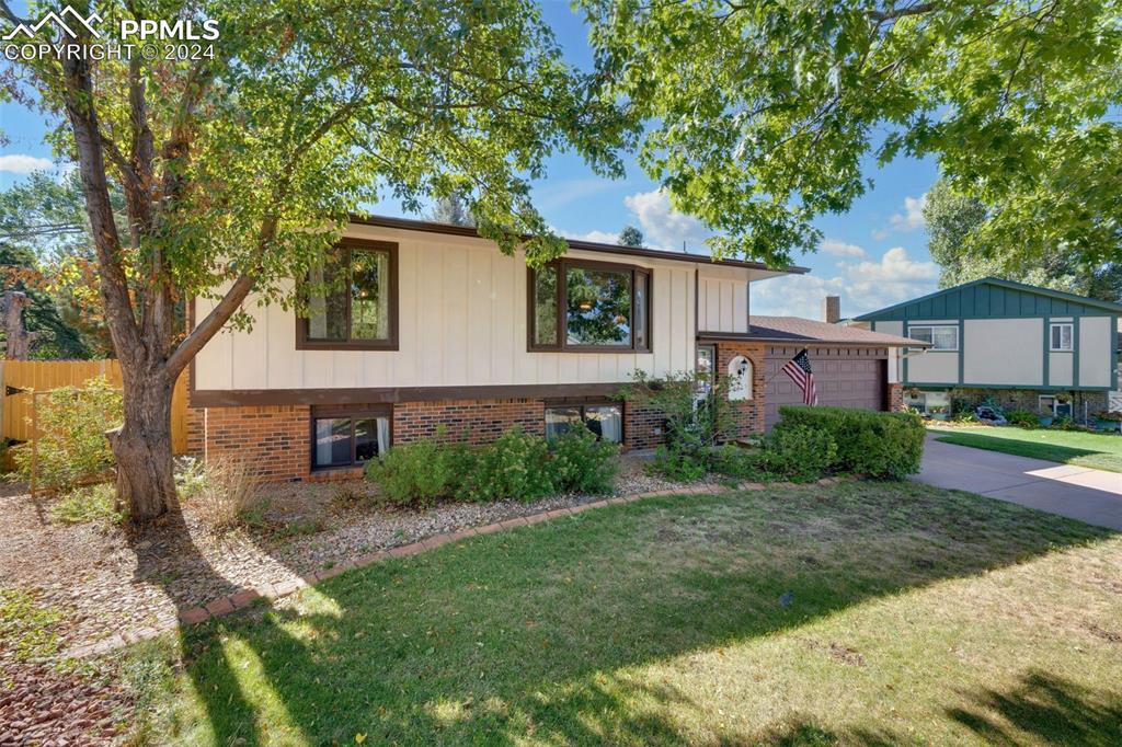 View of front of house with a garage and a front yard