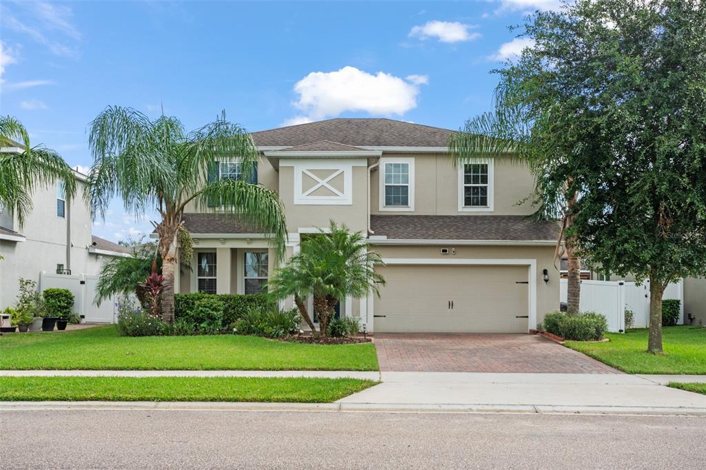 a front view of a house with a garden and a garage