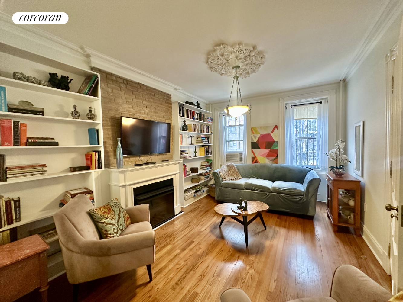 a living room with furniture a flat screen tv and a fireplace